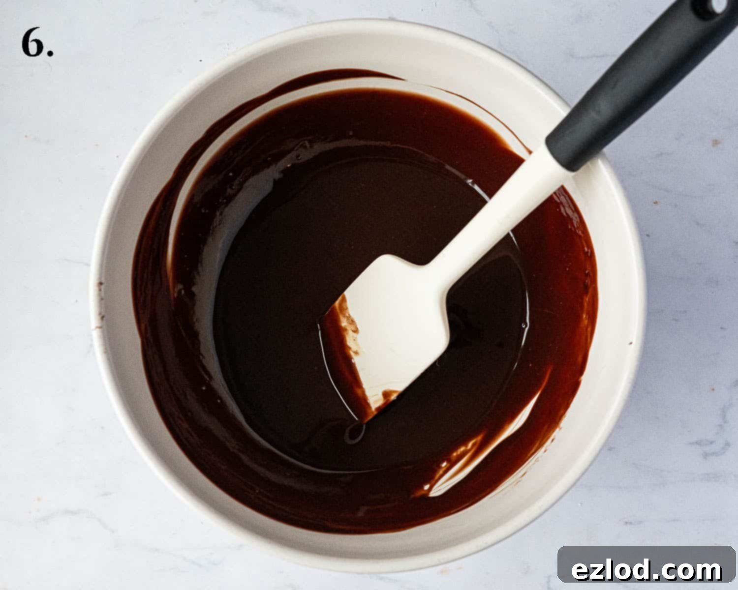 Rich Vegan Chocolate Pear Almond Tart 10 Step-by-step image showing dark chocolate and vegan butter melted together in a bowl, creating a smooth, glossy mixture.