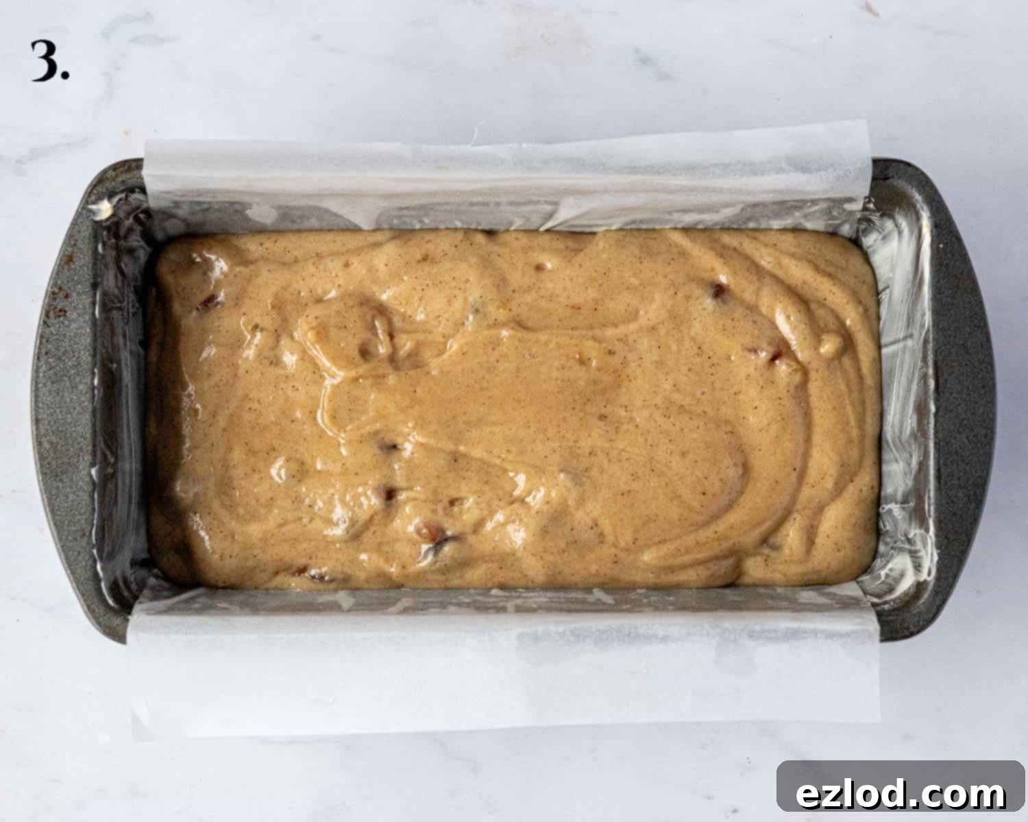 Zesty Vegan Marmalade Tea Loaf 7 Step 3: The smooth cake batter neatly placed into a lined loaf tin, prepared for baking.