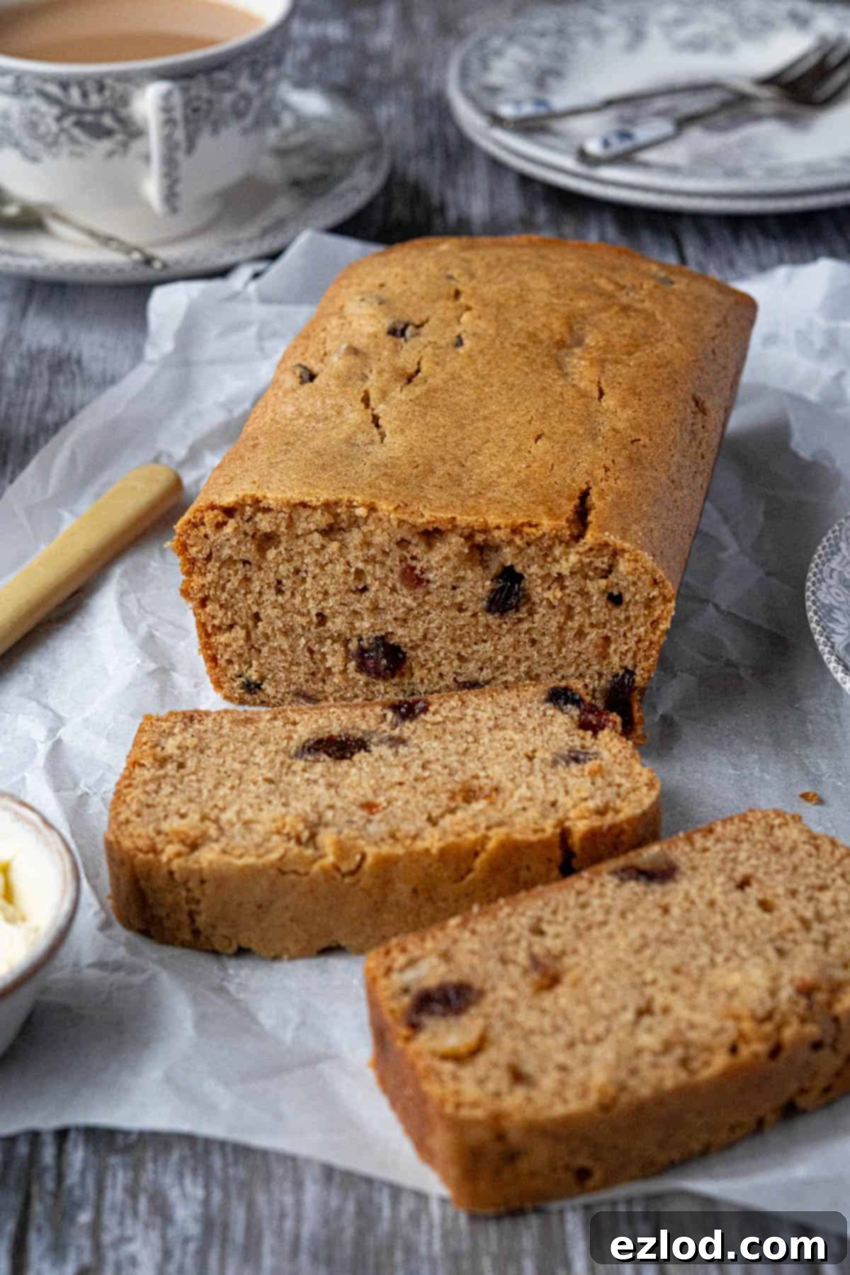 Zesty Vegan Marmalade Tea Loaf 9 An inviting view of the easy vegan marmalade tea loaf resting on baking parchment on a wooden table, accompanied by a soothing cup of tea.