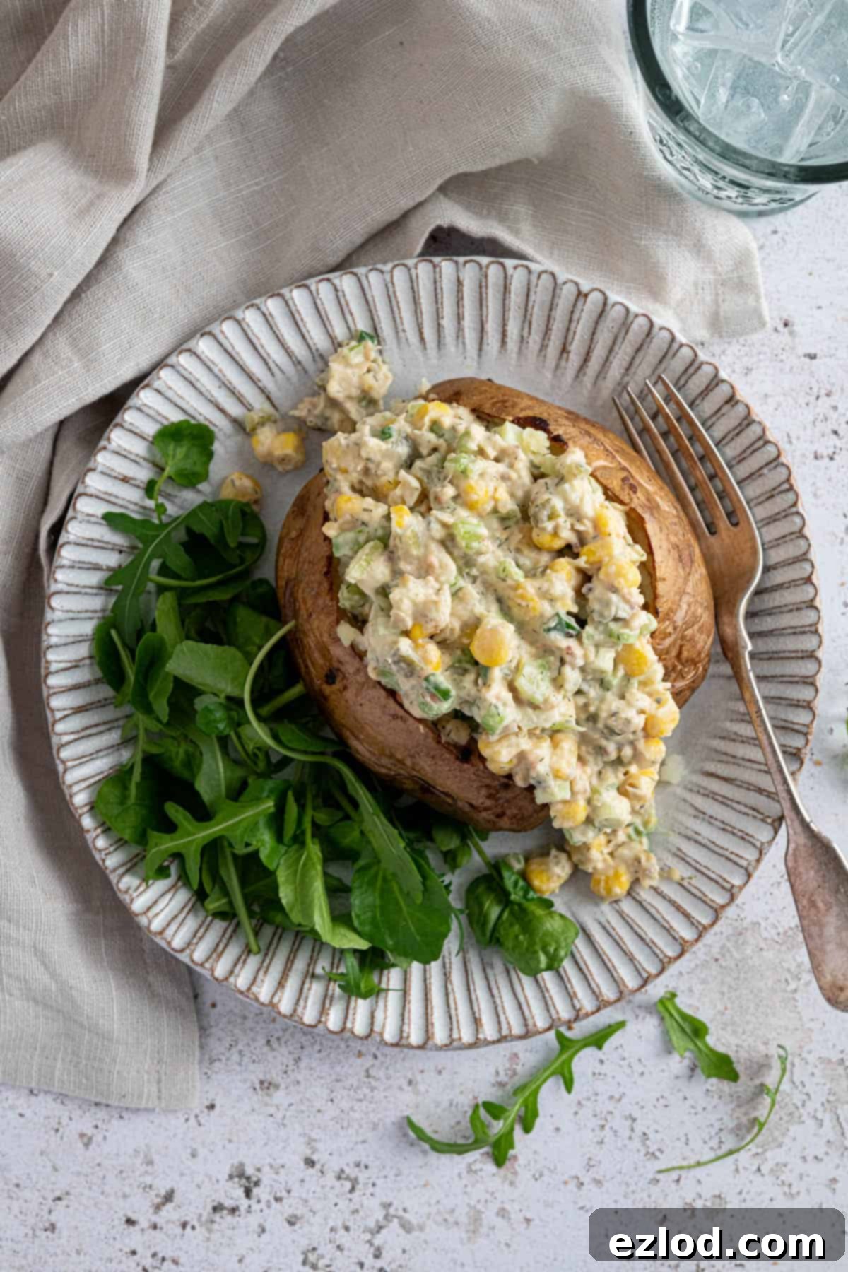Creamy Chickpea Salad 4 A beautifully plated baked potato, generously topped with creamy chickpea mayo salad and accompanied by a fresh green side salad.