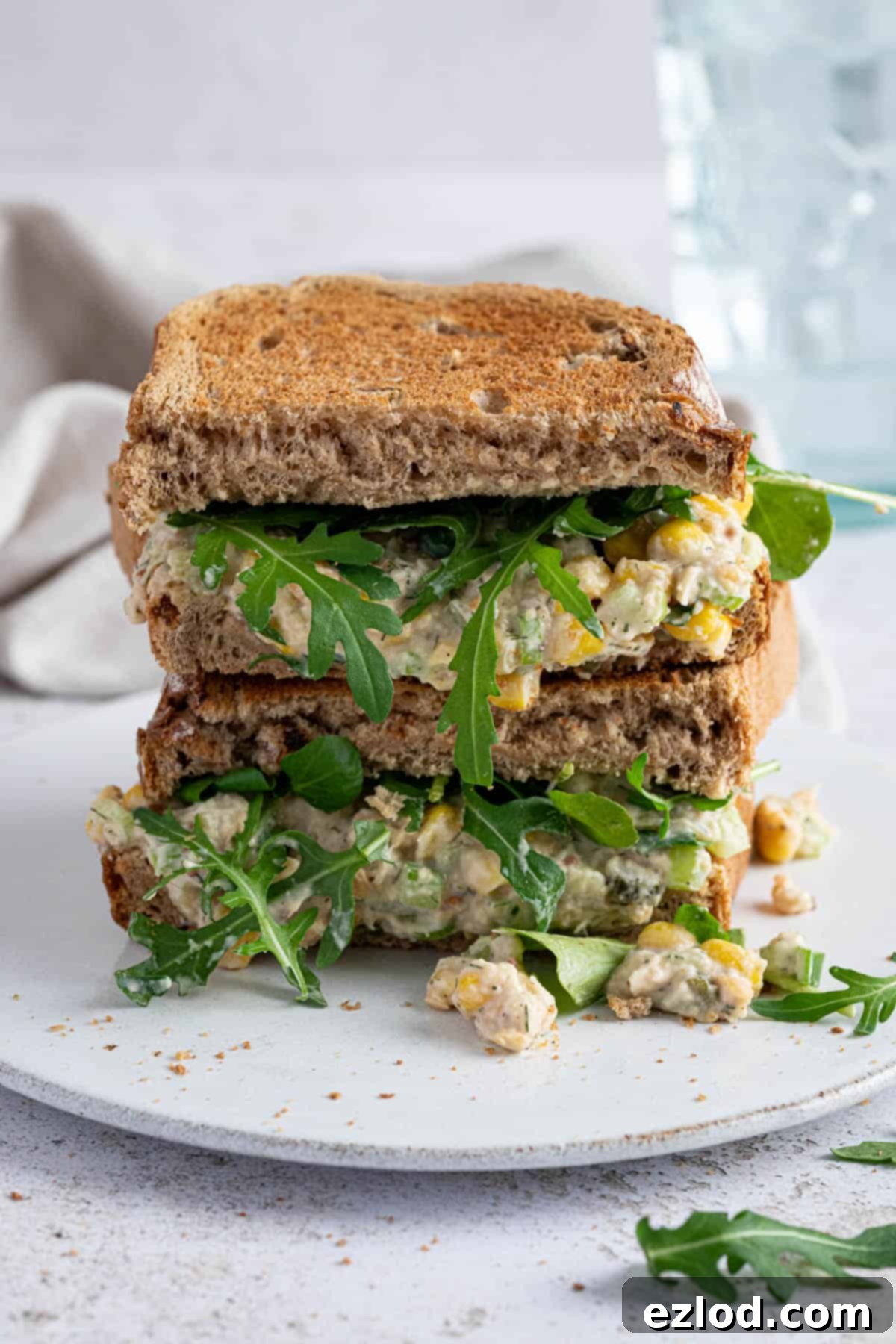 Creamy Chickpea Salad 8 A delicious chickpea mayo salad sandwich presented on a clean white plate, ready to be enjoyed.