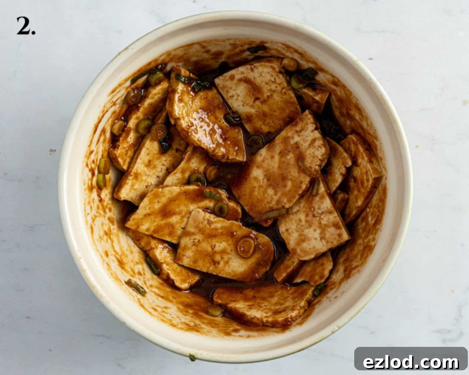 Pillowy Vegan Hoisin Tofu Bao Buns 6 Step 2, tofu slices coated in the hoisin marinade in a bowl.