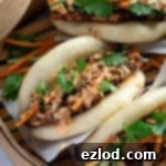 Pillowy Vegan Hoisin Tofu Bao Buns 10 Close up of hoisin tofu bao buns in a bamboo steamer.