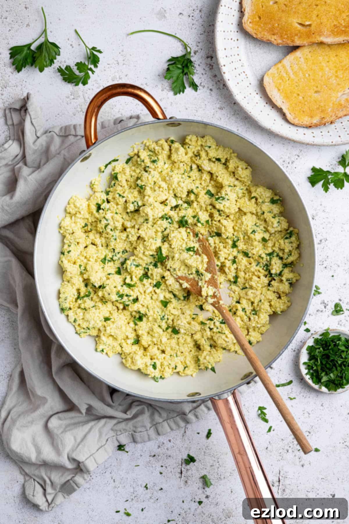 Golden Tofu Scramble 2 Tofu scramble bubbling gently in a white frying pan, ready to be served.