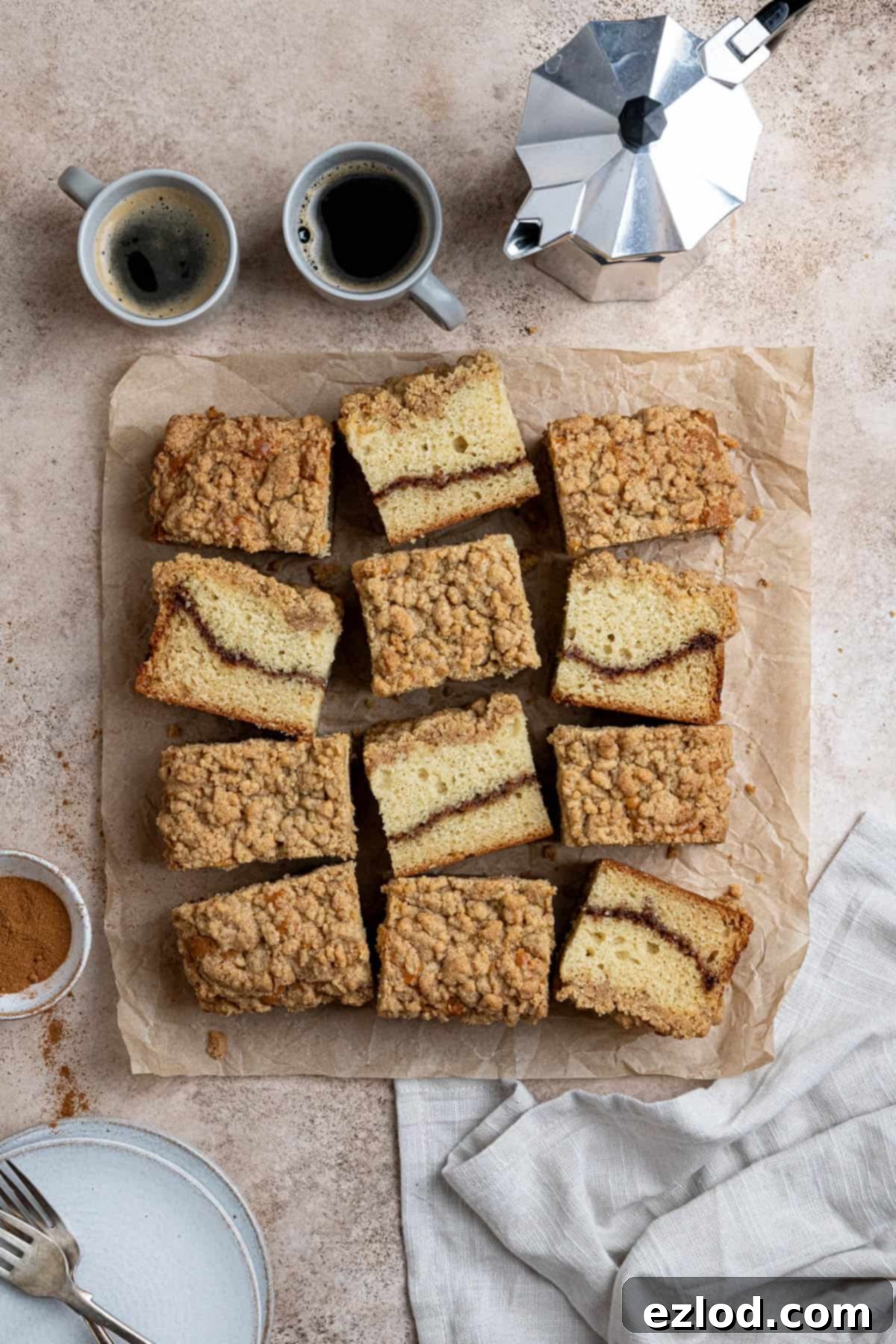 Plant-Based Streusel Cake 12 Vegan coffee cake on a sheet of baking paper with a pot of coffee and two espresso cups.