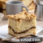 Plant-Based Streusel Cake 14 A slice of vegan coffee cake on a plate with a fork.
