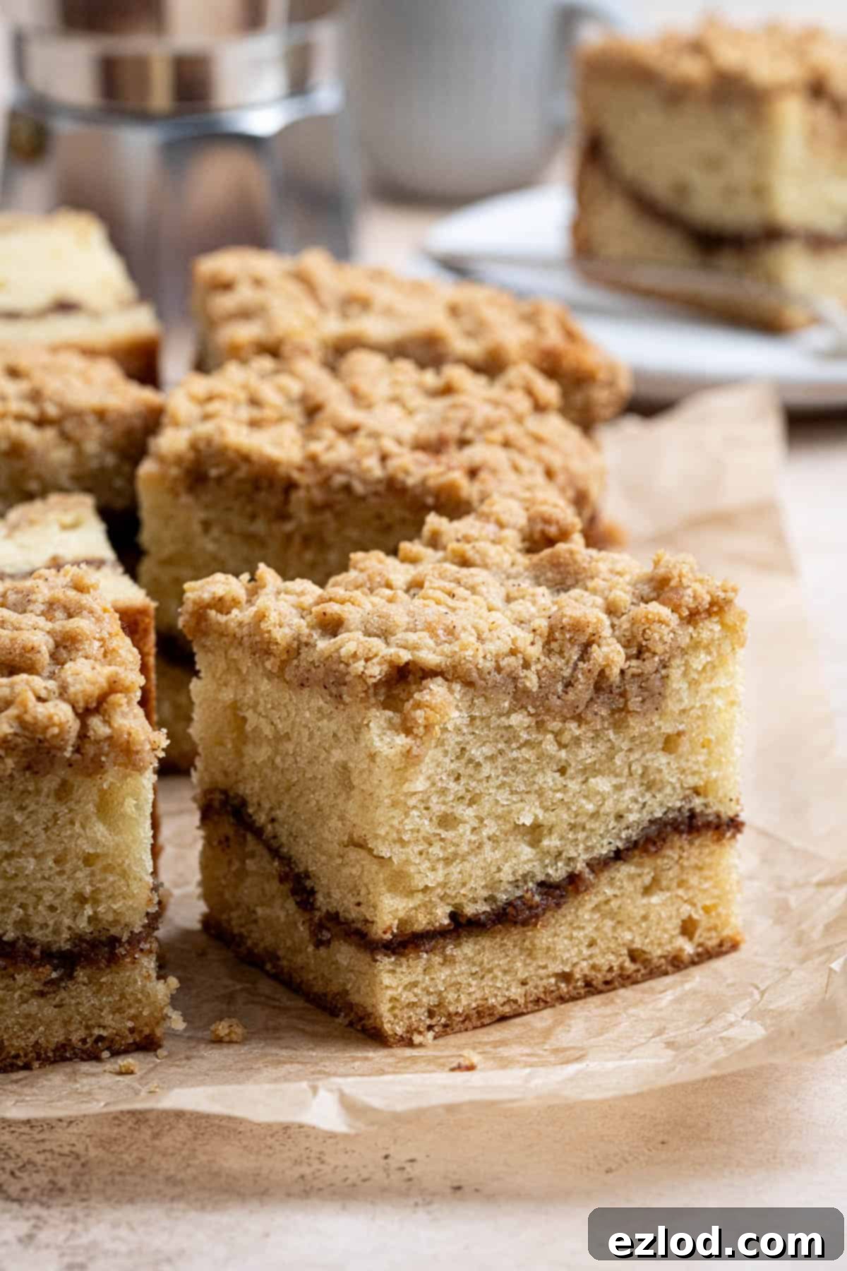 Plant-Based Streusel Cake 4 Close up of a square of vegan coffee cake on a sheet of baking paper.