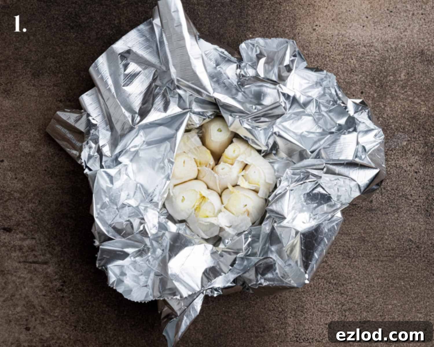 Velvety Vegan Roasted Garlic Cauliflower Soup 5 Step 1: A head of garlic with the top sliced off, drizzled with olive oil and wrapped in tin foil, ready for roasting.