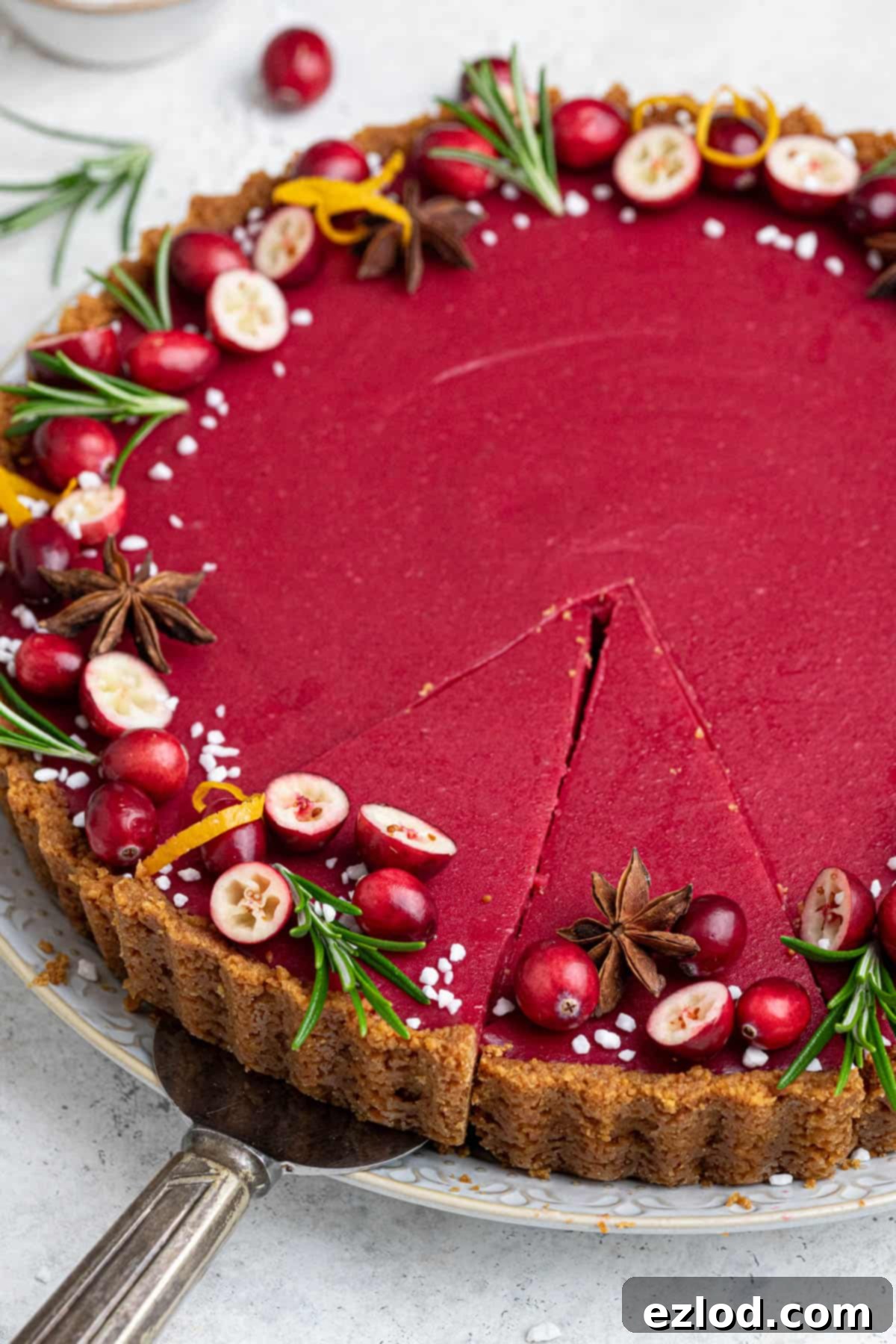 Zesty Vegan Cranberry Curd Tart 5 Close-up view of the Vegan Cranberry Curd Tart, showing a couple of neat slices removed and the smooth, glossy filling.