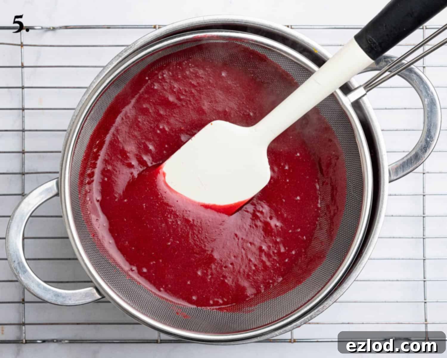 Zesty Vegan Cranberry Curd Tart 10 Step 5: Straining the blended cranberry mixture through a fine-mesh sieve into a saucepan to achieve a silky smooth curd.