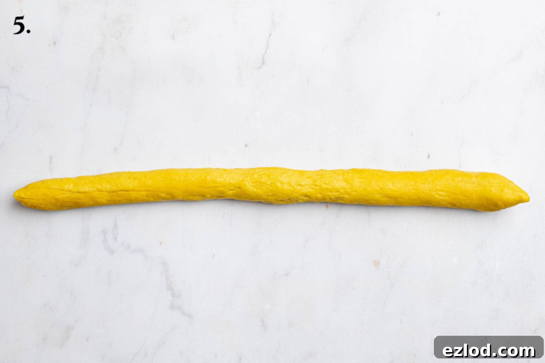 Plant-Based Saffron Buns for St. Lucia 11 Step 5, one of the balls of dough rolled into a rope.
