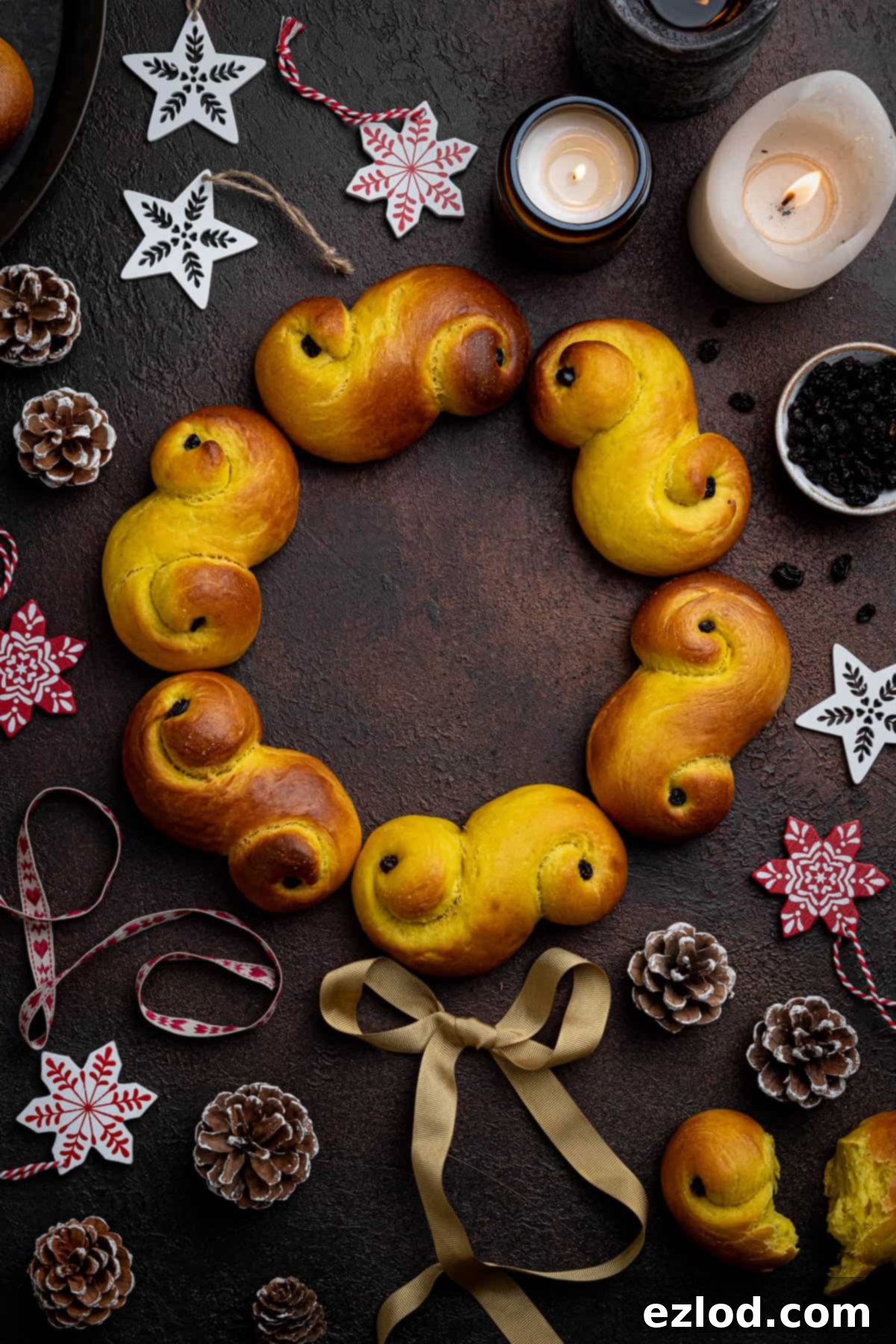 Plant-Based Saffron Buns for St. Lucia 5 Vegan St. Lucia buns arranged in a wreath shape surrounded by Christmas decorations.