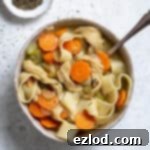 Plant-Based Chicken Noodle Soup 8 A bowl of vegan chicken noodle soup with a spoon and a bowl of dried thyme.
