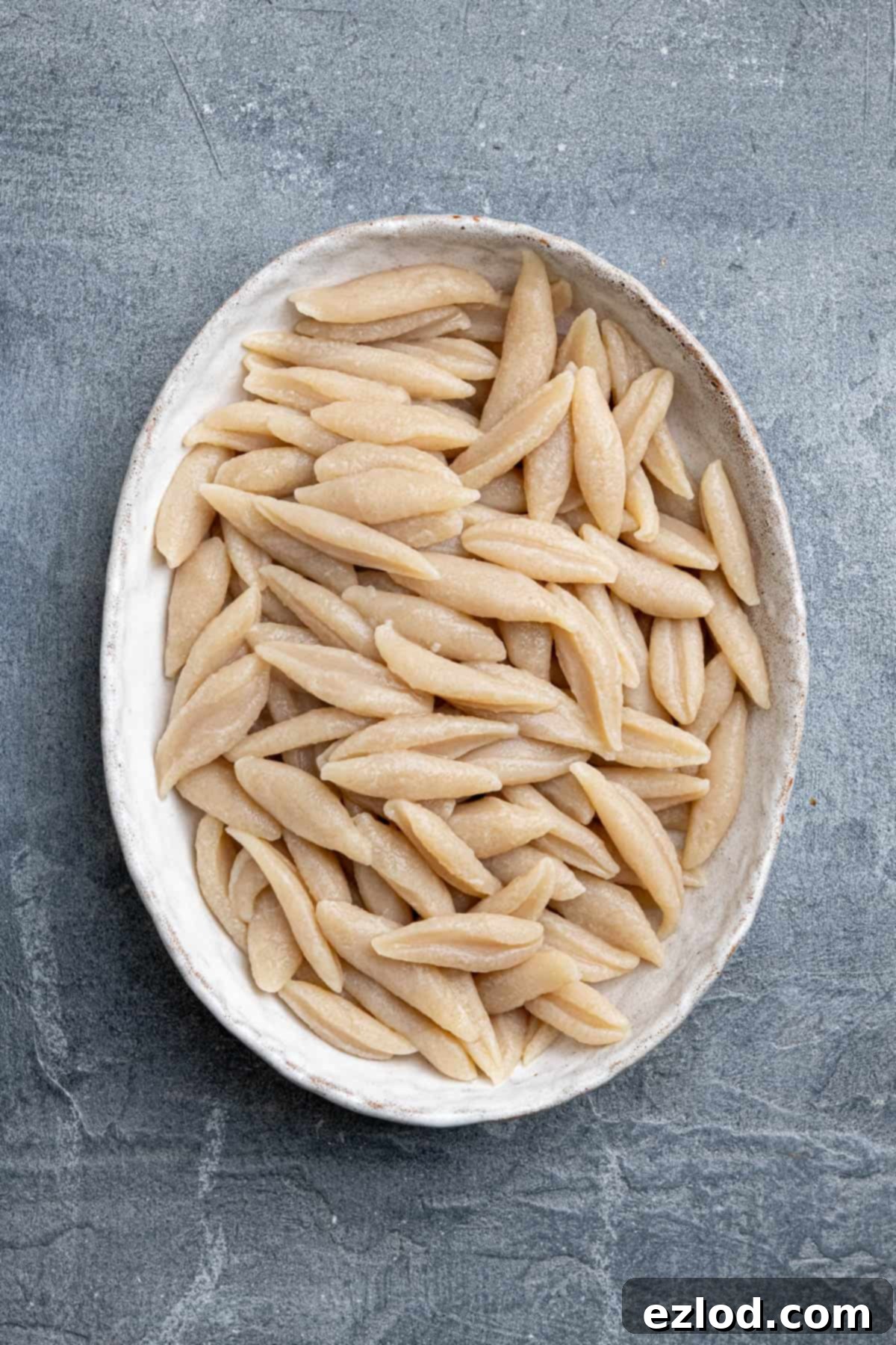 Velvety Gochujang Cream Pasta with Vegan Scissor Tofu 4 An oval bowl full of cooked scissor cut tofu pasta noodles with creamy gochujang sauce.