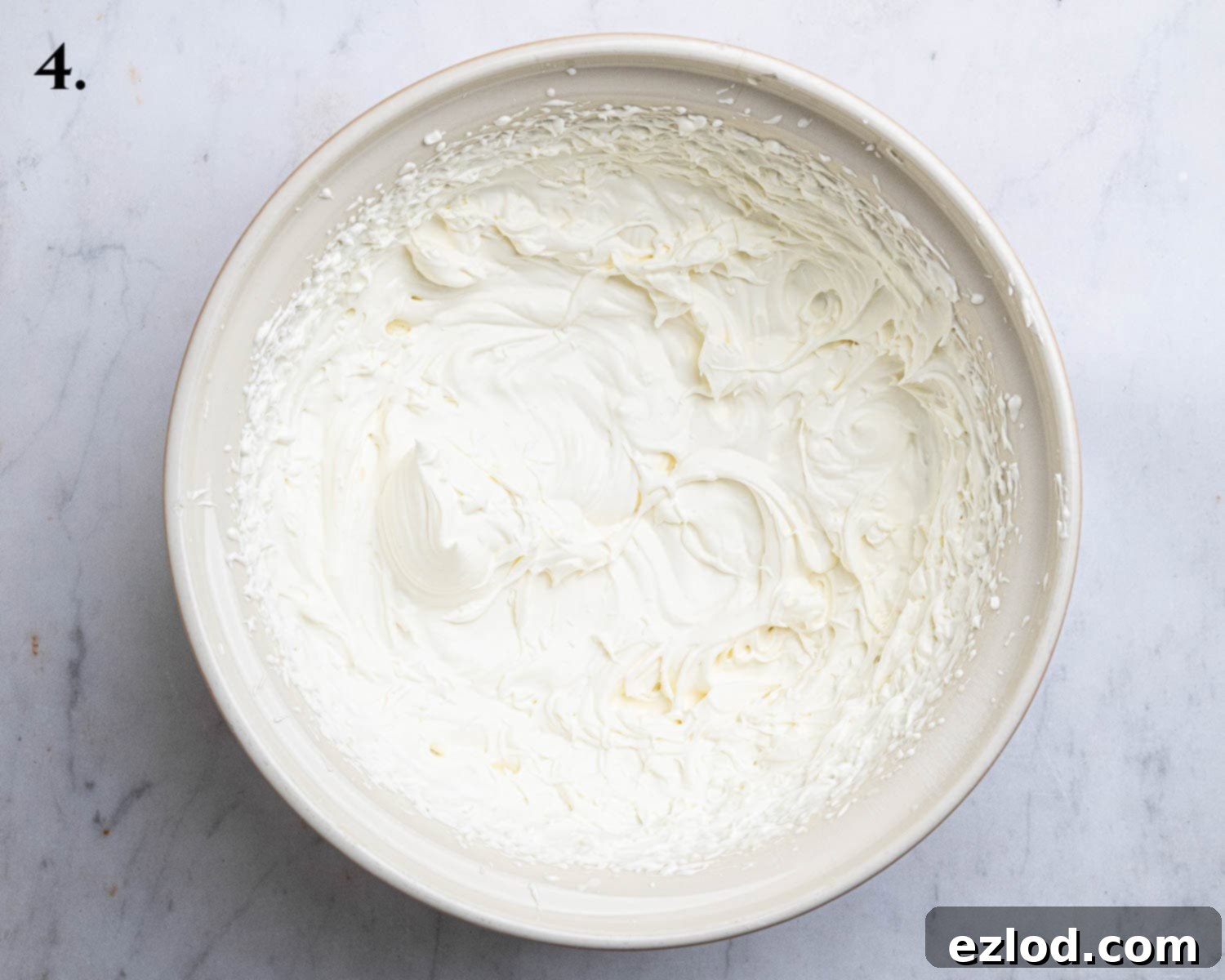 Decadent Vegan Biscoff Cheesecake 8 Step 4: Vegan whipping cream and icing sugar have been whipped to stiff peaks in a separate bowl.