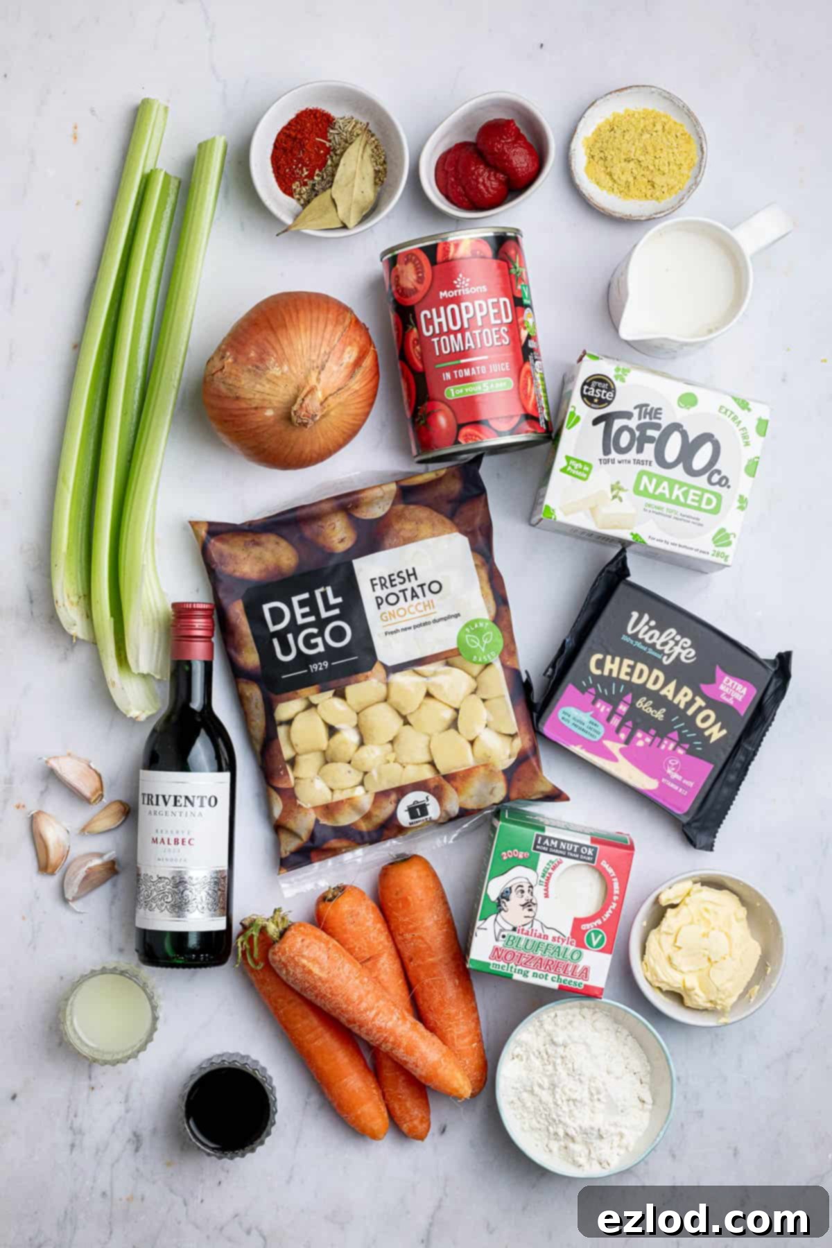 Gooey Vegan Gnocchi Bake 3 A flat lay photograph showcasing all the fresh and pantry ingredients needed to prepare the cheesy vegan gnocchi bake, including gnocchi, tofu, vegetables, spices, and vegan cheeses.