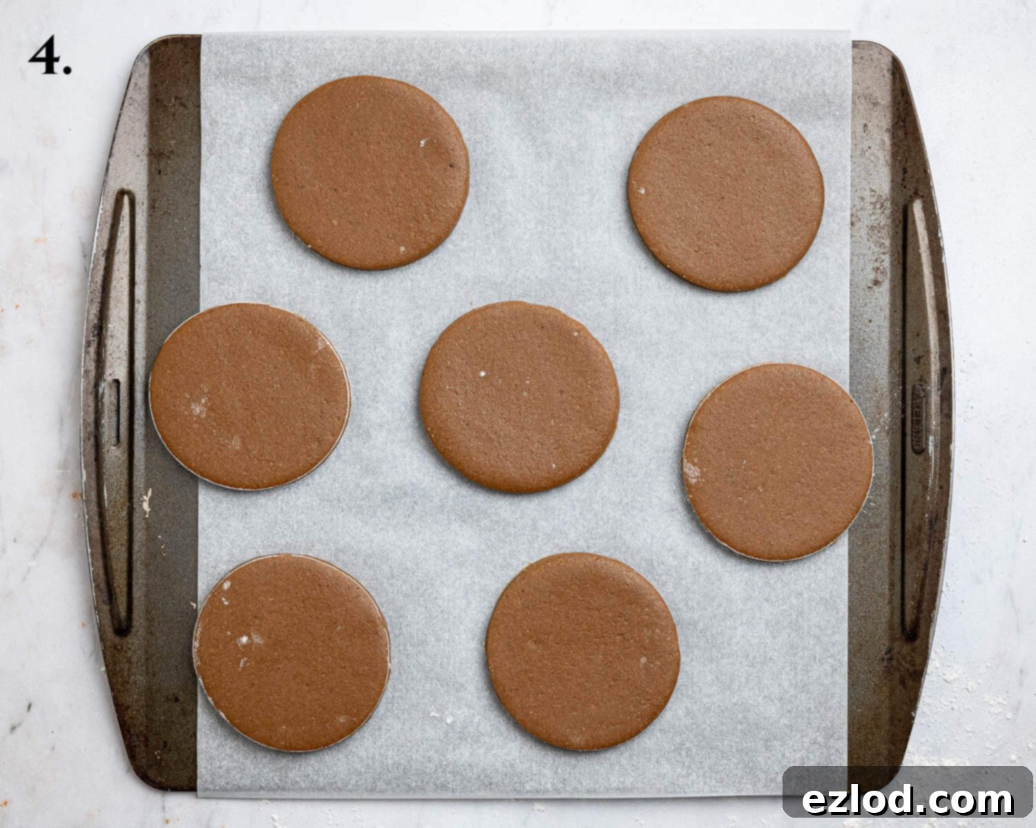 Plant-Based Jamaican Bulla Delight 8 Step 4: Neatly cut-out round bulla cake dough pieces arranged on a parchment-lined baking sheet, evenly spaced and ready for the oven.