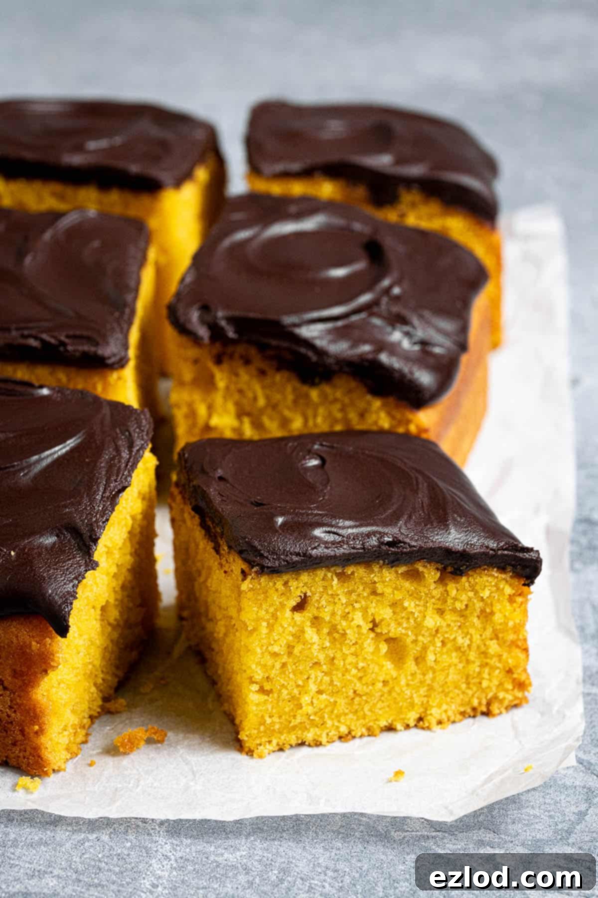 Sun-Kissed Vegan Brazilian Carrot Cake 9 Slices of vegan Brazilian carrot cake on a sheet of baking paper.