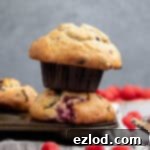 Plant-Based Chocolate Raspberry Muffins 13 A stack of two vegan choc chip raspberry muffins in a muffin pan.