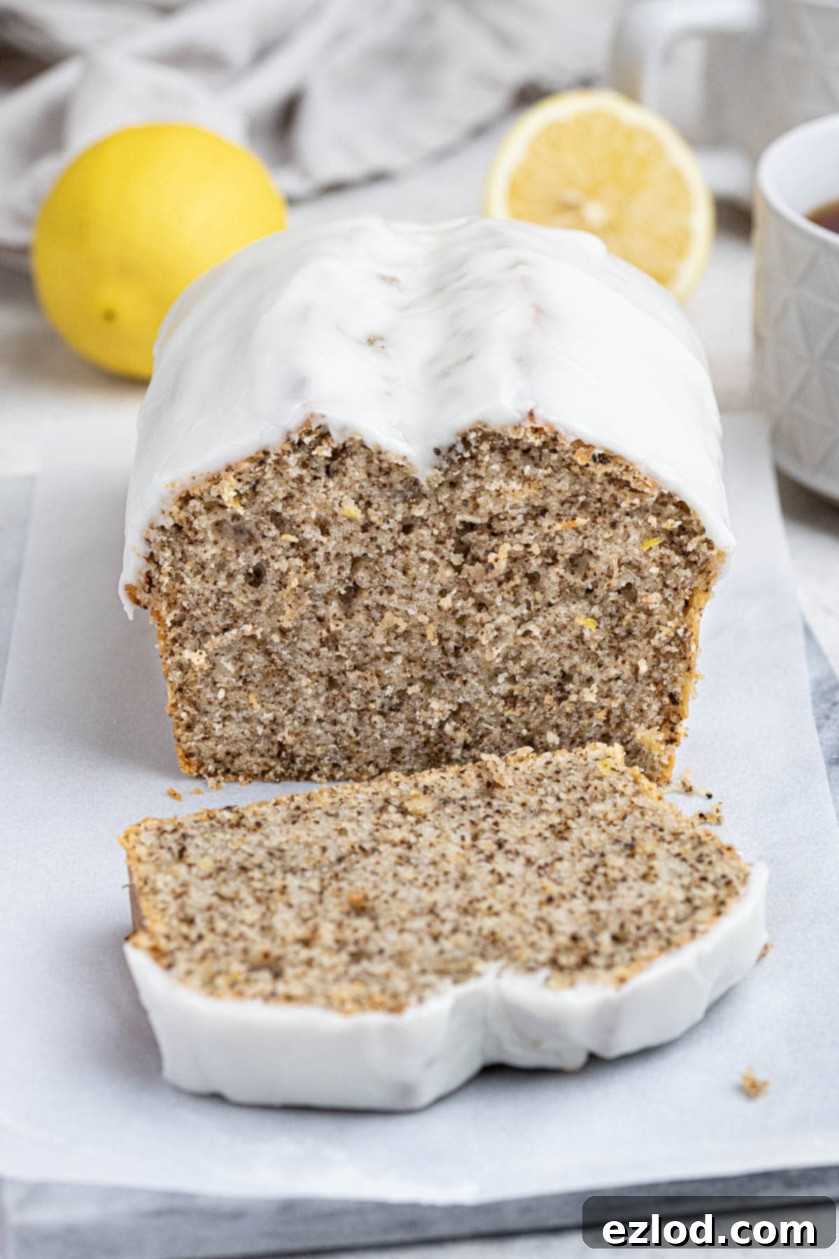 Zesty Vegan Earl Grey Lemon Cake 9 The fully iced vegan Earl Grey lemon cake, topped with a delicate lemon glaze, presented on a stylish marble board, ready to be enjoyed.