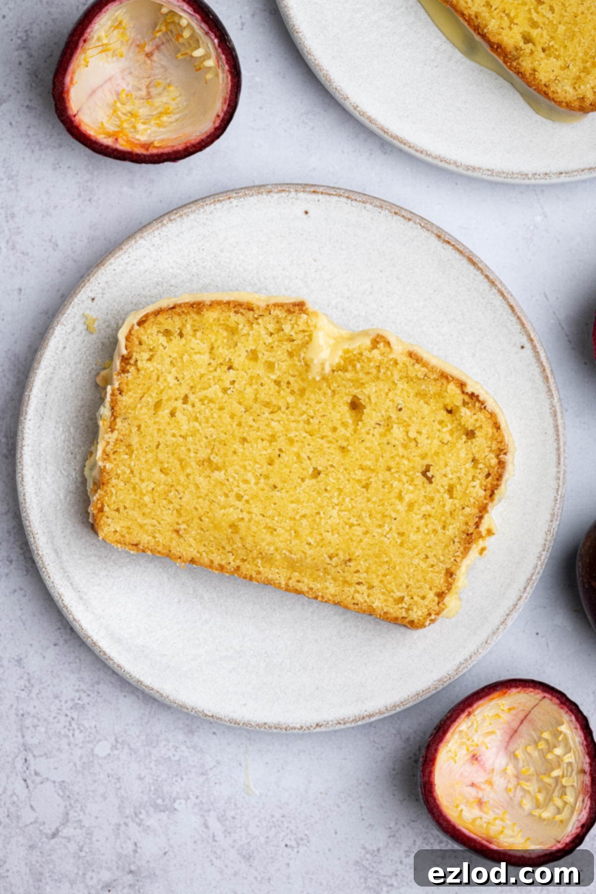 Luscious Vegan Passion Fruit Delight 4 A delectable slice of vegan passion fruit cake, showing its moist crumb and vibrant glaze, resting on a pristine white plate.