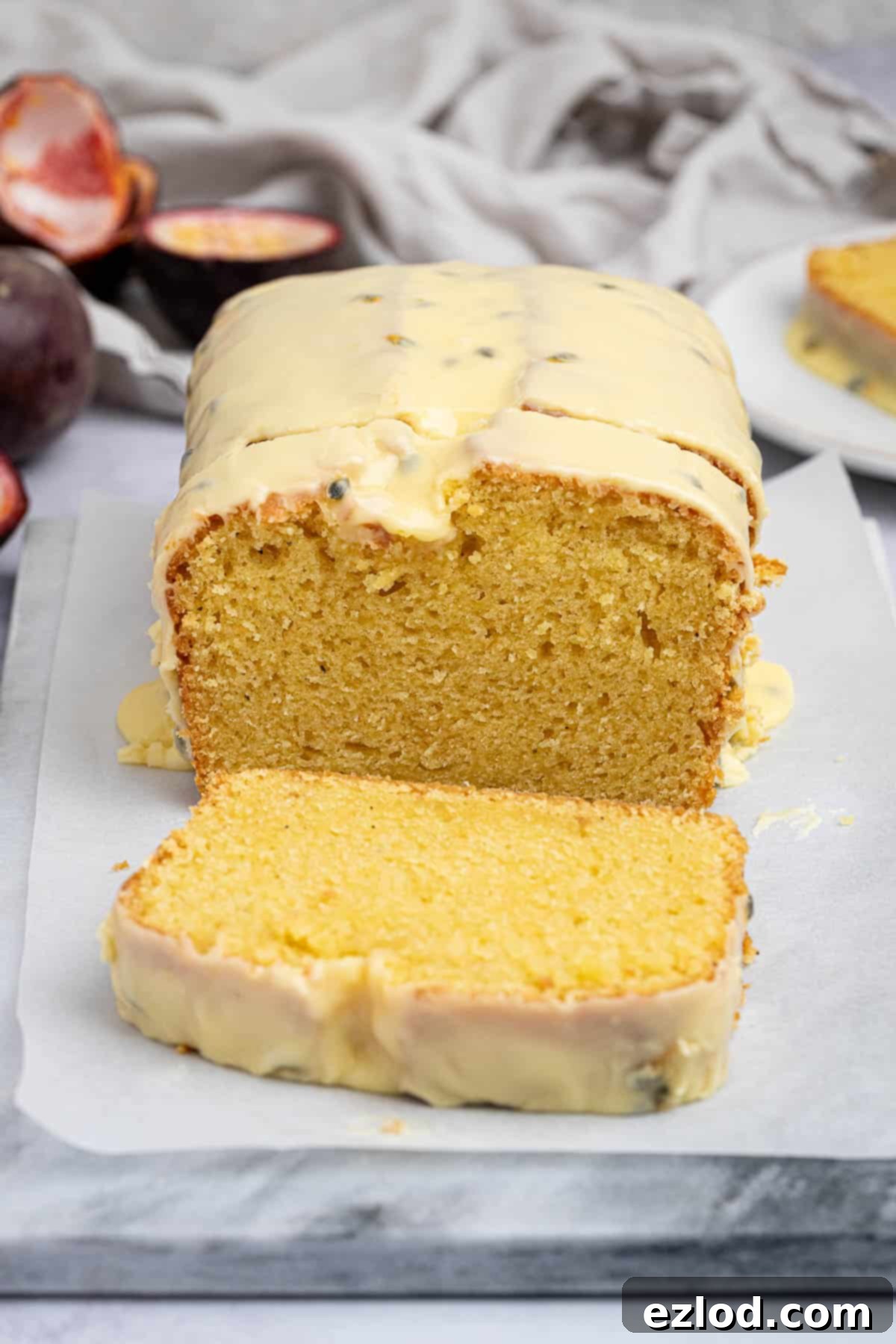 Luscious Vegan Passion Fruit Delight 10 A stunning vegan passion fruit loaf cake, beautifully sliced and presented on a elegant marble board, showcasing its moist interior.