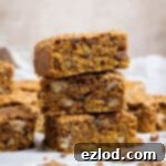Vegan Pumpkin Spice Oat Bars 8 A stack of vegan pumpkin oatmeal cookie bars on a sheet of baking paper.