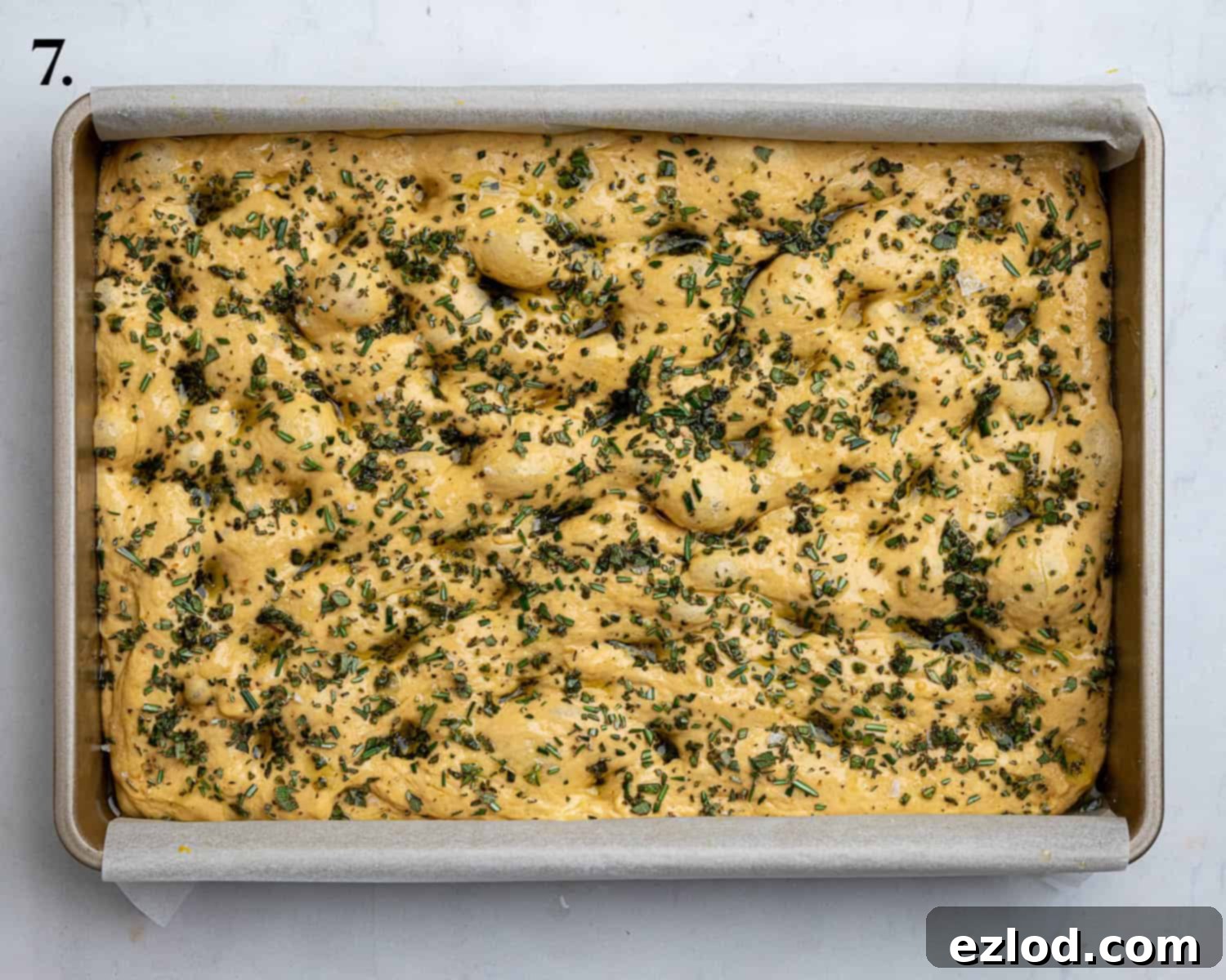 Autumn Spiced Vegan Pumpkin Focaccia 11 Step 7, the dough topped with herbs and olive oil before baking.