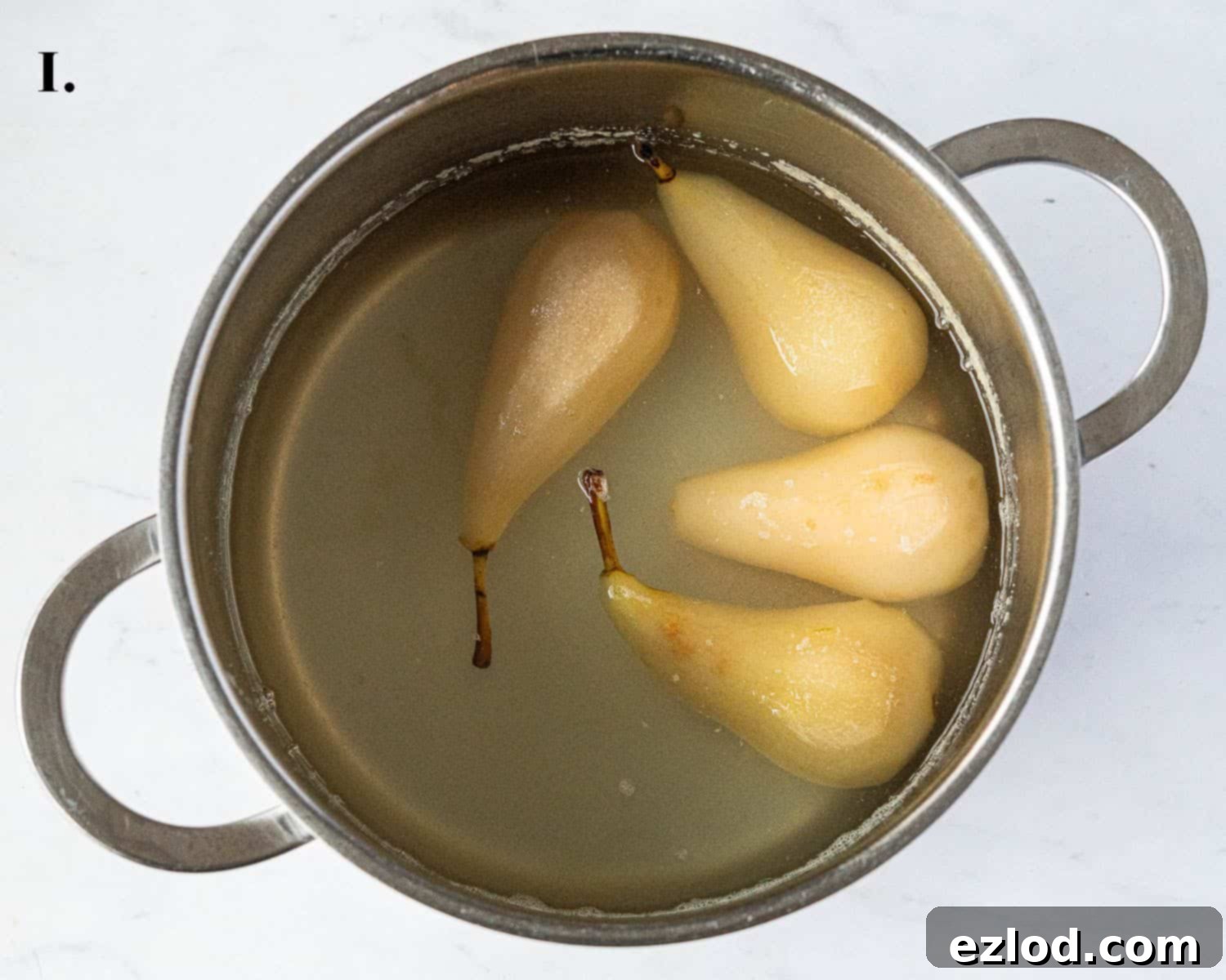 Gingered Pear & Almond Vegan Tart 5 Step 1 in the baking process: The peeled pears gently poaching in a pan with sugar syrup.