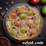 Elegant Vegan Apple Hazelnut Frangipane Tart 19 Vegan apple hazelnut frangipane tart on a dark background with apples and a bowl of hazelnuts.