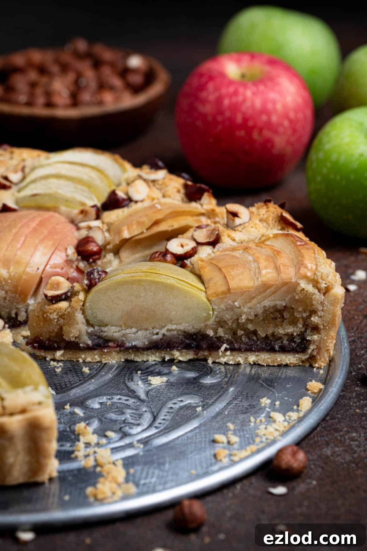 Elegant Vegan Apple Hazelnut Frangipane Tart 4 A close-up view of a perfectly baked slice of the vegan apple hazelnut frangipane tart, showcasing its layers and inviting texture.