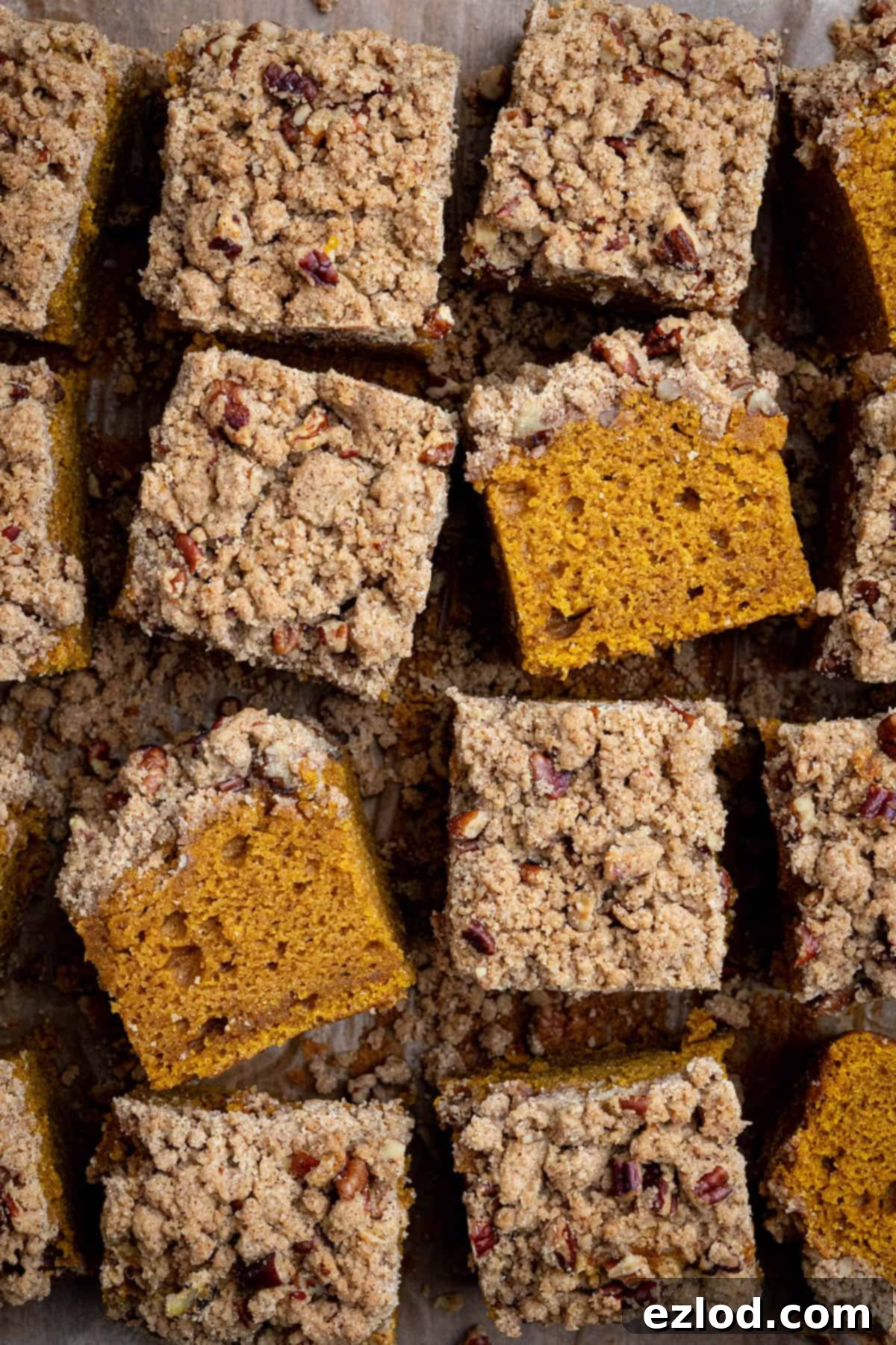 Spiced Vegan Pumpkin Streusel 4 Four perfectly cut squares of vegan pumpkin crumb cake arranged artfully, showcasing the fluffy cake and golden-brown streusel topping.