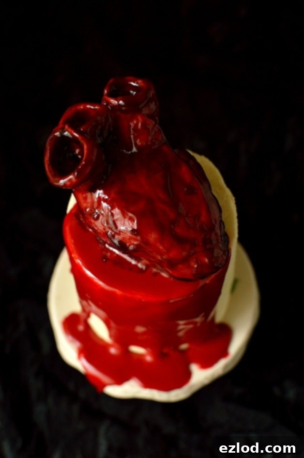 Haunted Heart Halloween Cupcakes 5 realistic bleeding heart cakes on top of mini red velvet layer cakes with ganache 'blood'
