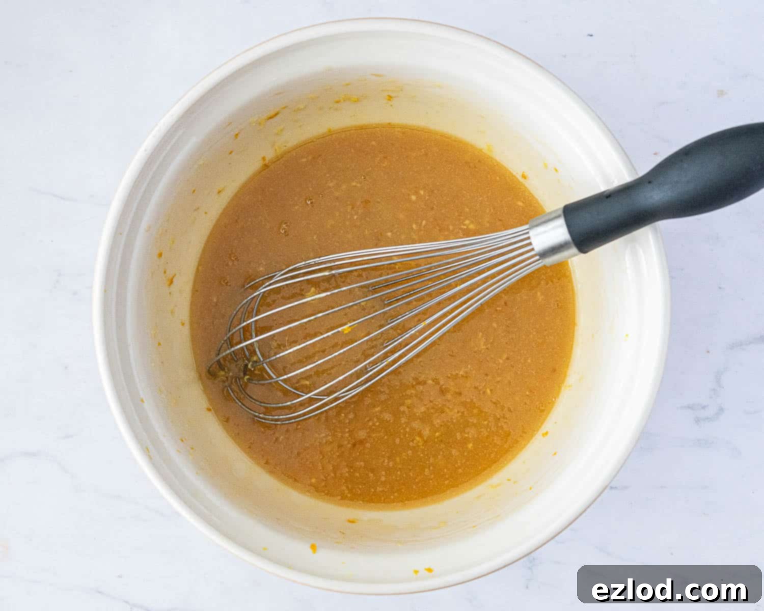 Sun-Kissed Vegan Ginger Cake with Tangy Marmalade 5 Step 2: A bowl containing the perfectly blended wet ingredients for the cake, including sugar, milk, orange zest, and fresh ginger.