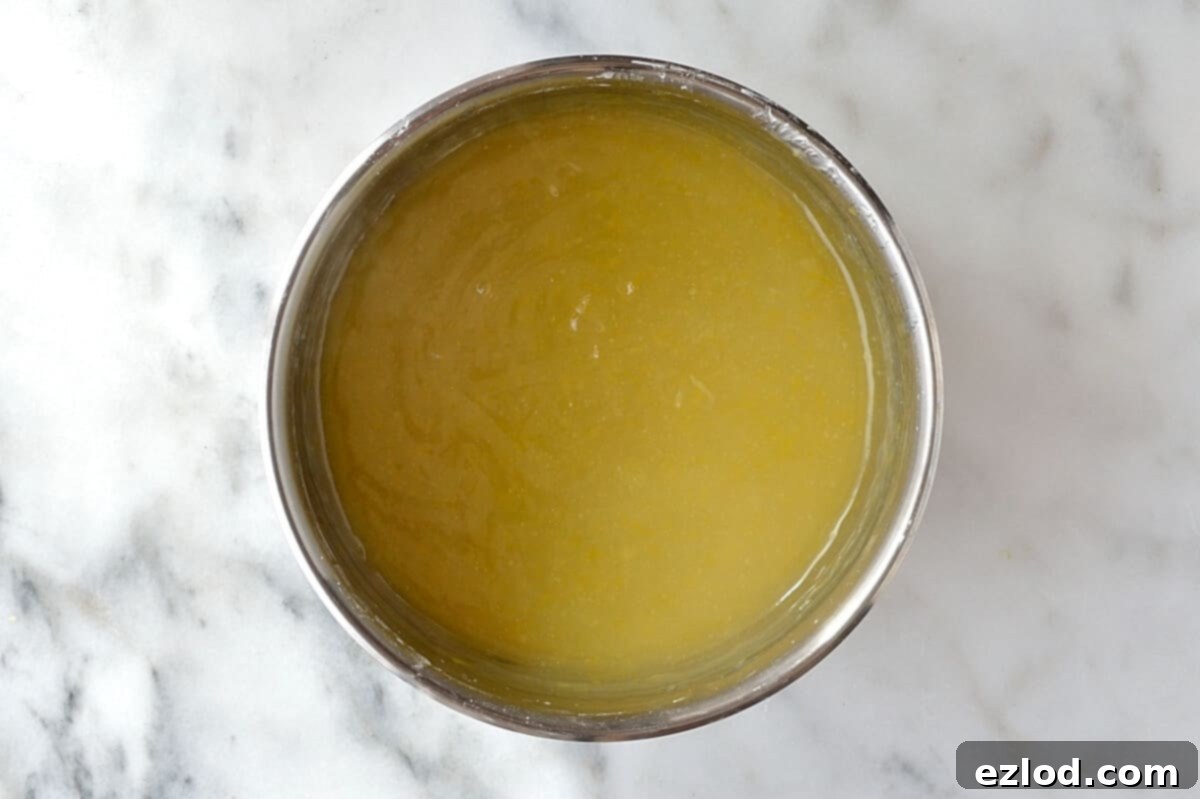Zesty Plant-Based Lemon Cream 8 Vegan lemon curd mixture thickening in a saucepan on the stove, showing the creamy texture developing. This step is crucial for achieving the desired consistency of the egg-free lemon spread.
