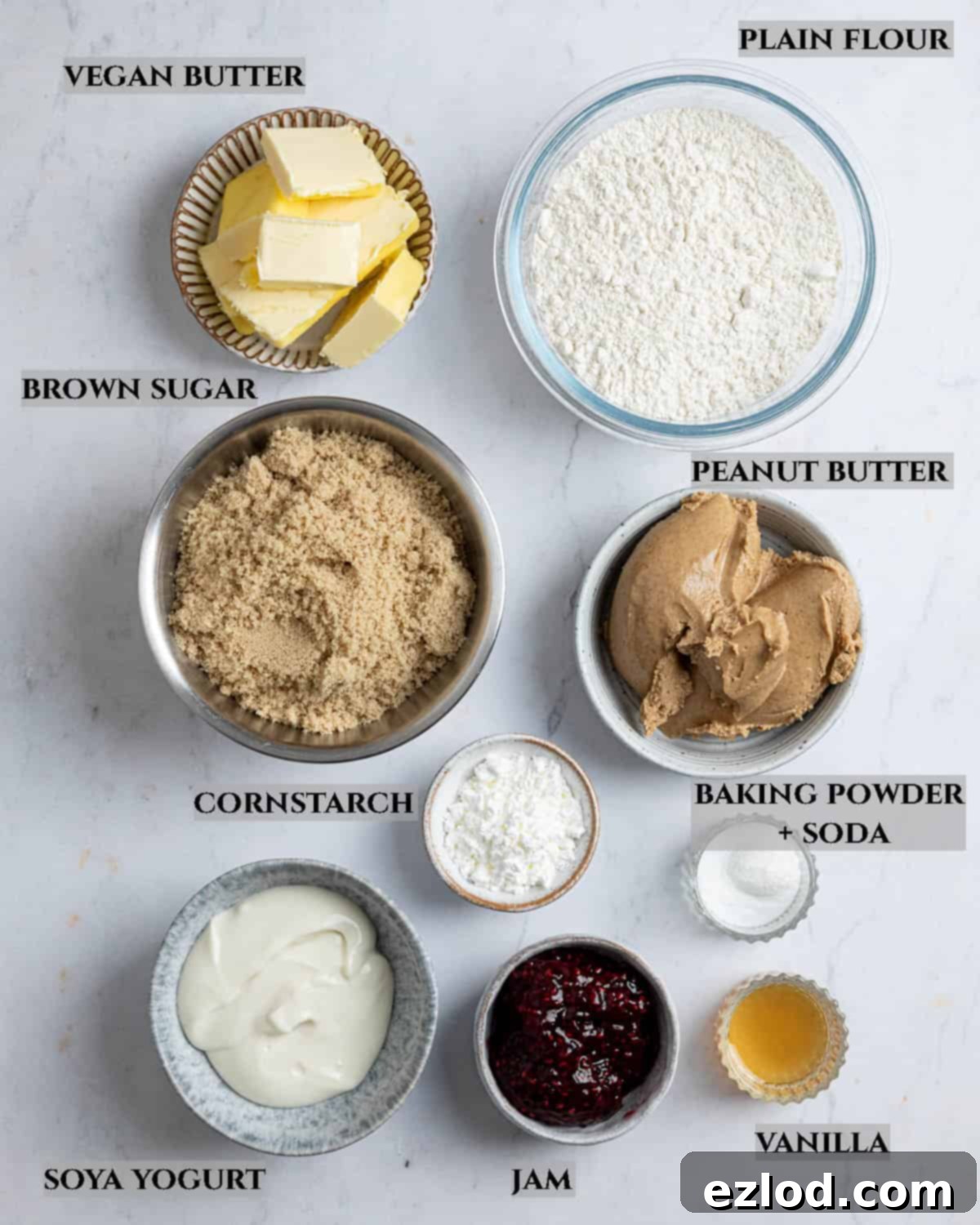 Irresistible Vegan Peanut Butter Blondies 3 A labelled photo displaying all the essential ingredients in individual bowls for making vegan peanut butter blondies.