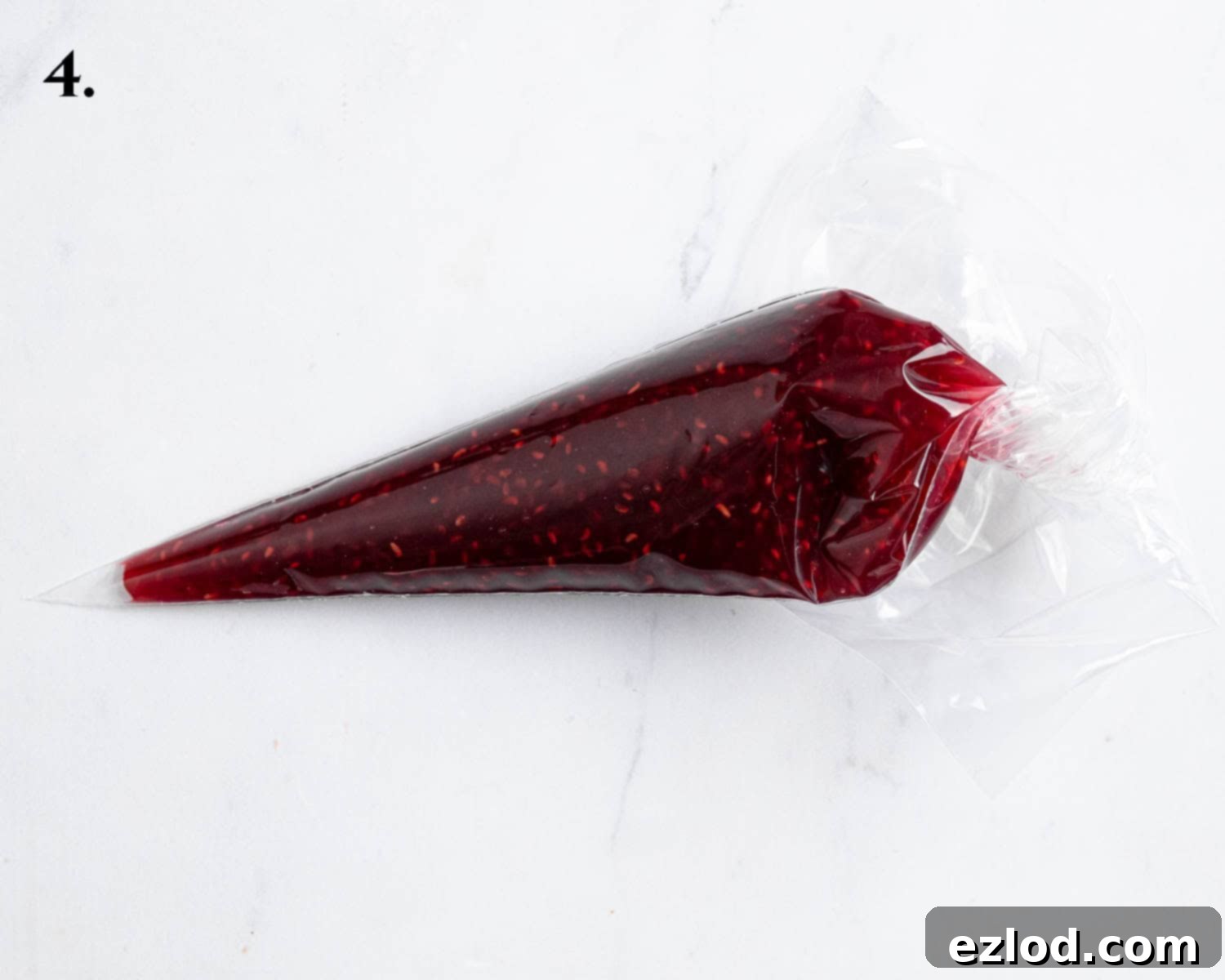 Irresistible Vegan Peanut Butter Blondies 8 Step 4: Raspberry jam, warmed and ready for swirling, is neatly contained within a piping bag.