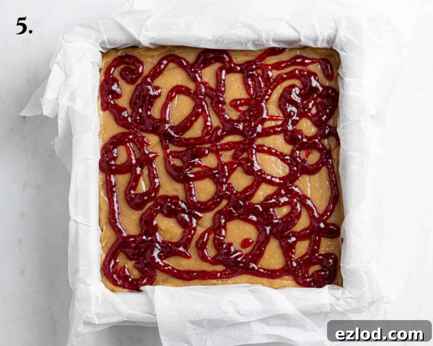 Irresistible Vegan Peanut Butter Blondies 9 Step 5: The blondies are now ready for baking, topped with artistic swirls of raspberry jam piped over the batter.