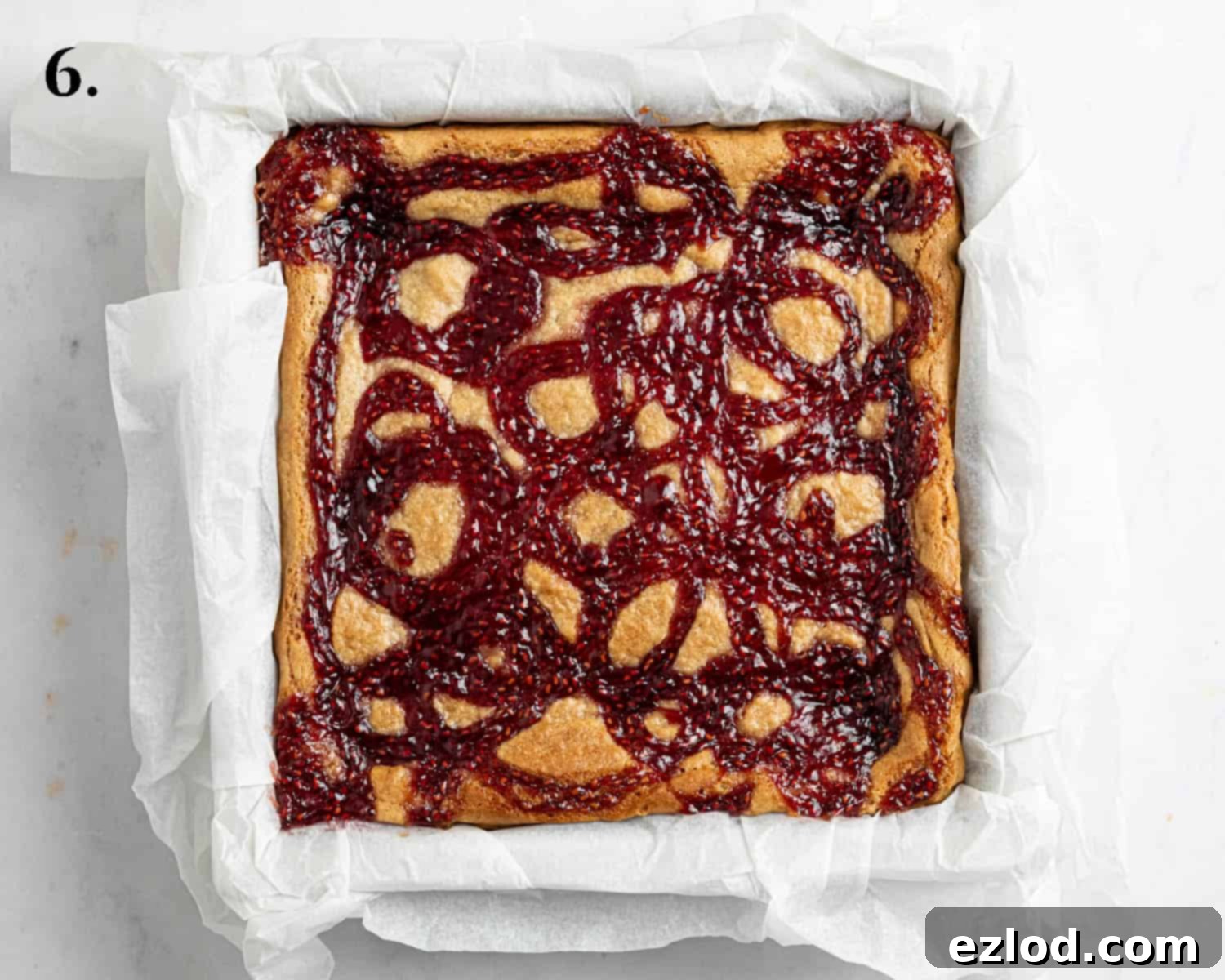 Irresistible Vegan Peanut Butter Blondies 10 Step 6: The freshly baked vegan peanut butter blondies, golden brown with jam swirls, resting in the tin after removal from the oven.