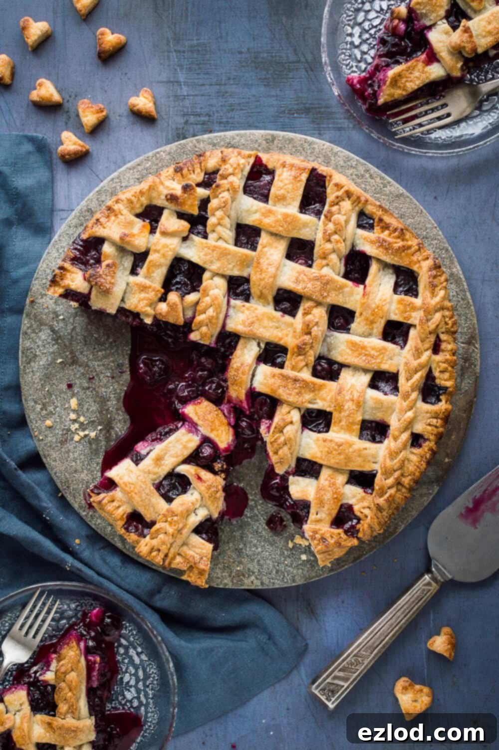 Vegan Blueberry Pie with a Flaky Coconut Oil Crust 4 Overhead view of a freshly baked vegan blueberry pie, with two slices on glass plates