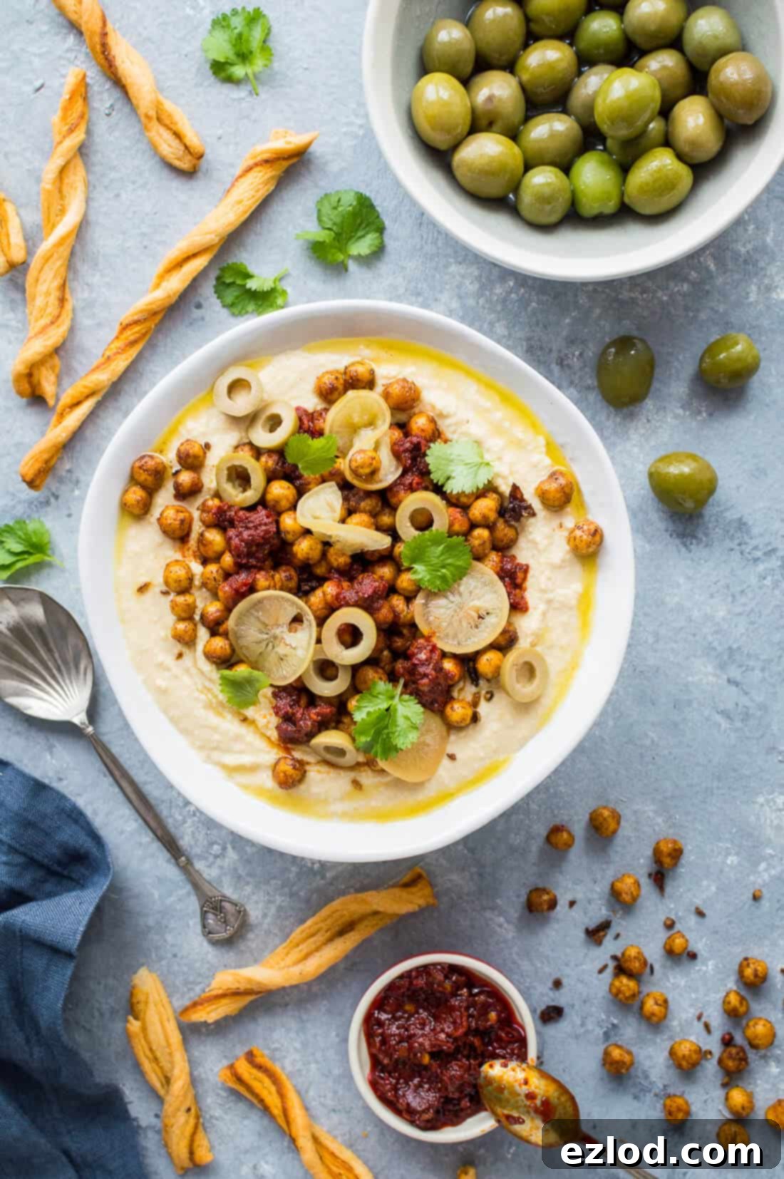 Loaded hummus bowl with crispy north African chickpeas, rose harissa, preserved lemon and olives. Perfect for snacking or entertaining! #vegan #hummus #plantbased #healthy