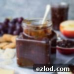 Hummus Bowl with Crispy North African Chickpeas and Fiery Caraway Jam 16 A jar of tomato, chilli and caraway jam on a marble board with cheese, crackers, grapes and apple