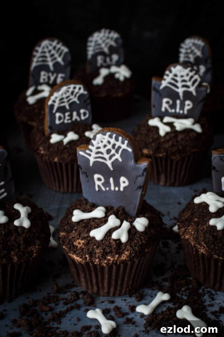 Plant-Based Graveyard Halloween Treats 5 graveyard cupcakes - vegan chocolate cupcakes topped with decorated gingerbread tombstones, oreo soil and vegan royal icing bones.