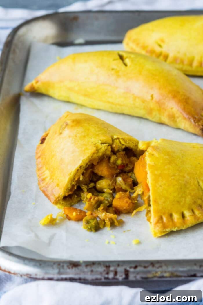 A closer look at a delicious, eggless and dairy-free Jamaican vegetable patty, highlighting its flaky golden crust and rich, plant-based Caribbean filling. Perfect for vegan meals and baking. #plantbased #veganfood #jamaicanpatties #meatfreemeals Close up a vegan Jamaican vegetable patty sliced in half, revealing the vibrant, spiced vegetable filling within the golden pastry.