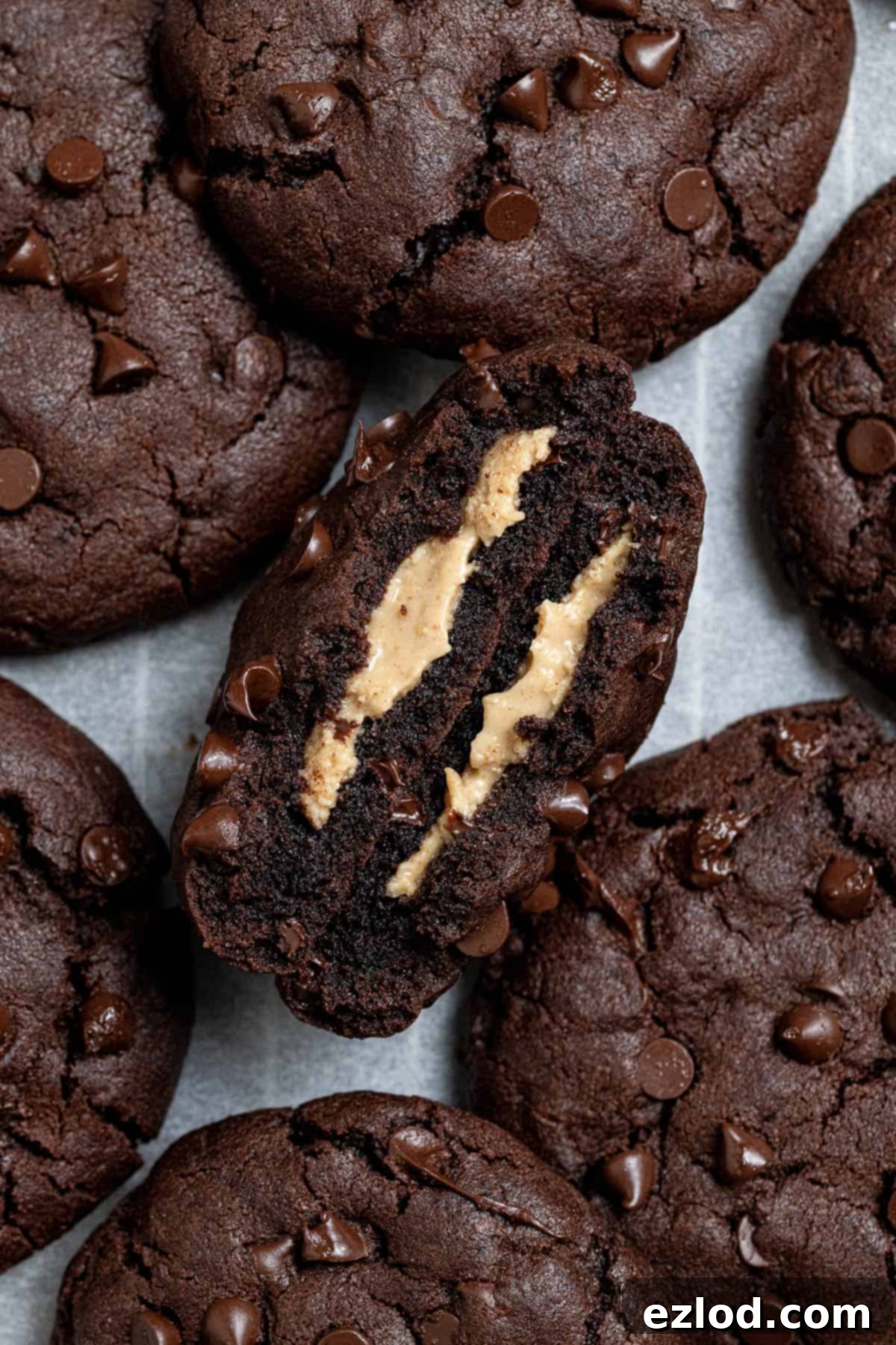 Close-up of a perfectly baked vegan peanut butter stuffed chocolate cookie broken in half, revealing its gooey peanut butter filling.