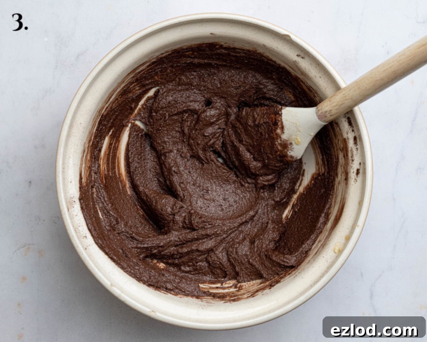 Step 3: Mixing in wet ingredients and cocoa powder to the creamed butter.