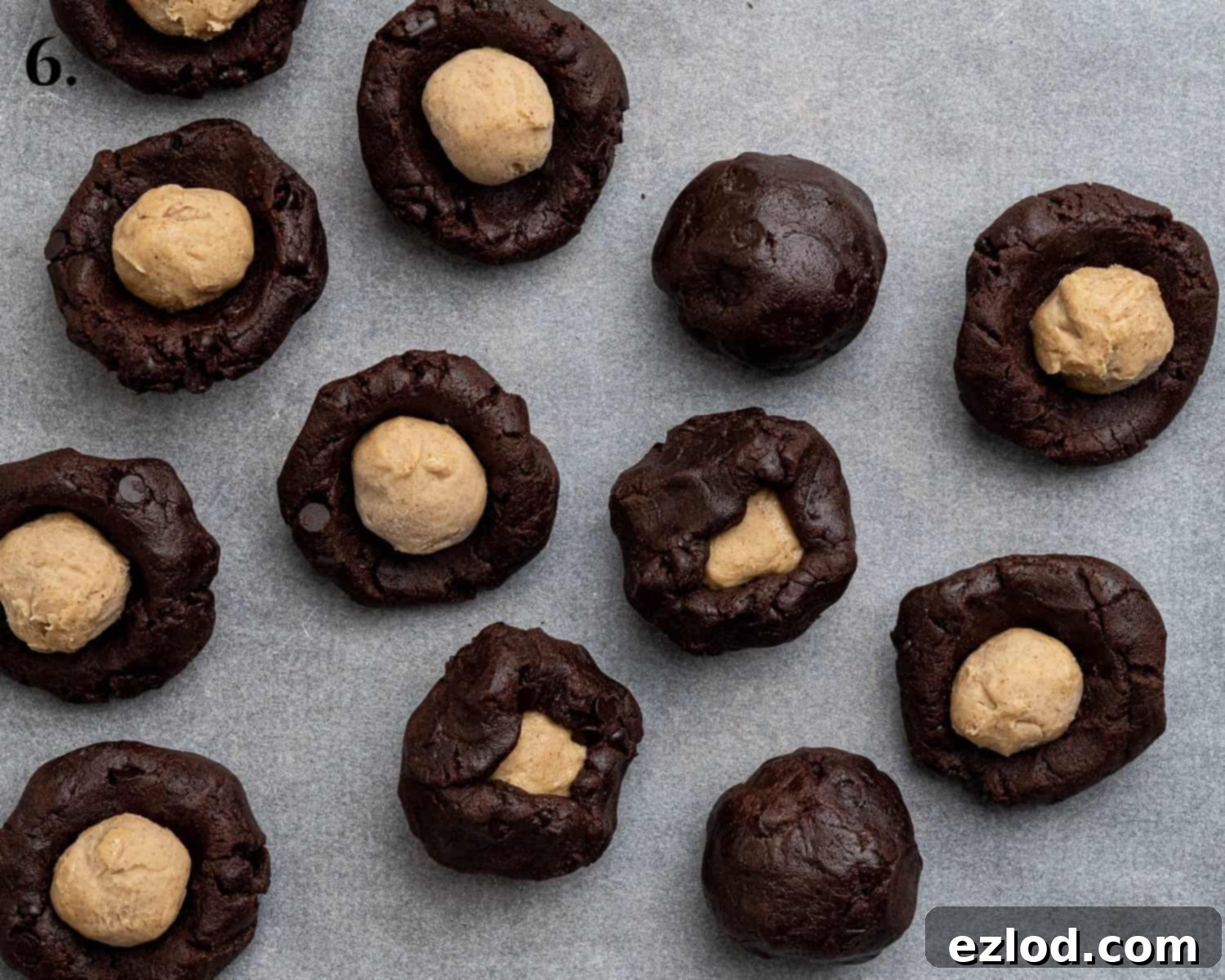 Step 6: Placing frozen peanut butter balls into cookie dough and sealing.