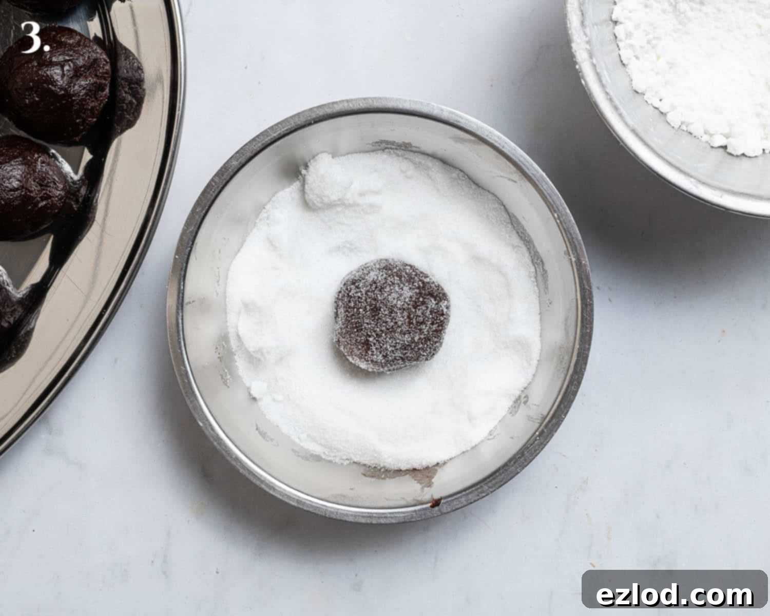 Step 3, rolling the dough balls in caster sugar.