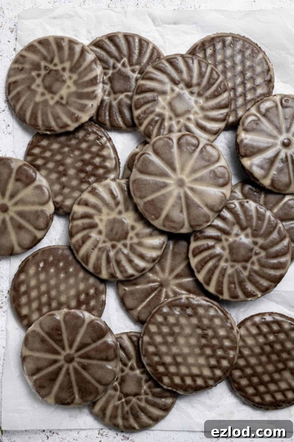 A delightful stack of vegan glazed gingerbread cookies on baking paper.