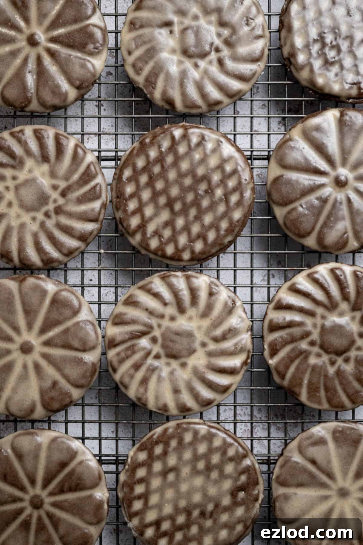 A detailed close-up of vegan glazed gingerbread cookies cooling on a wire rack.